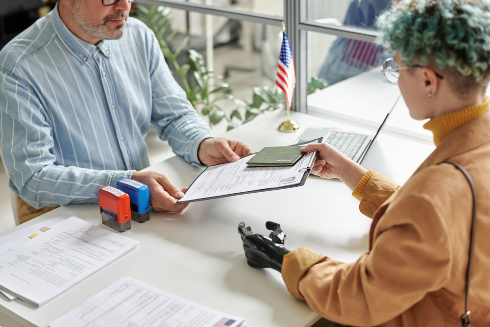 Canada Visa Documents: A picture showing female applicant handing over Canada visa documents to consular officer.
