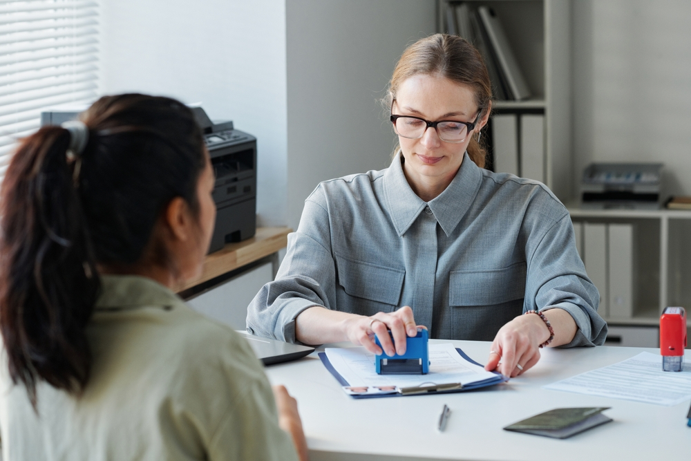 UK Work Visa Interview: A picture showing a UK Visa applicant waiting as the consular officer stamped the application.