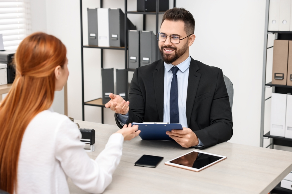 What Not to Say During a Canada Work Permit Interview: Photo of a woman having interview with embassy worker in office 
