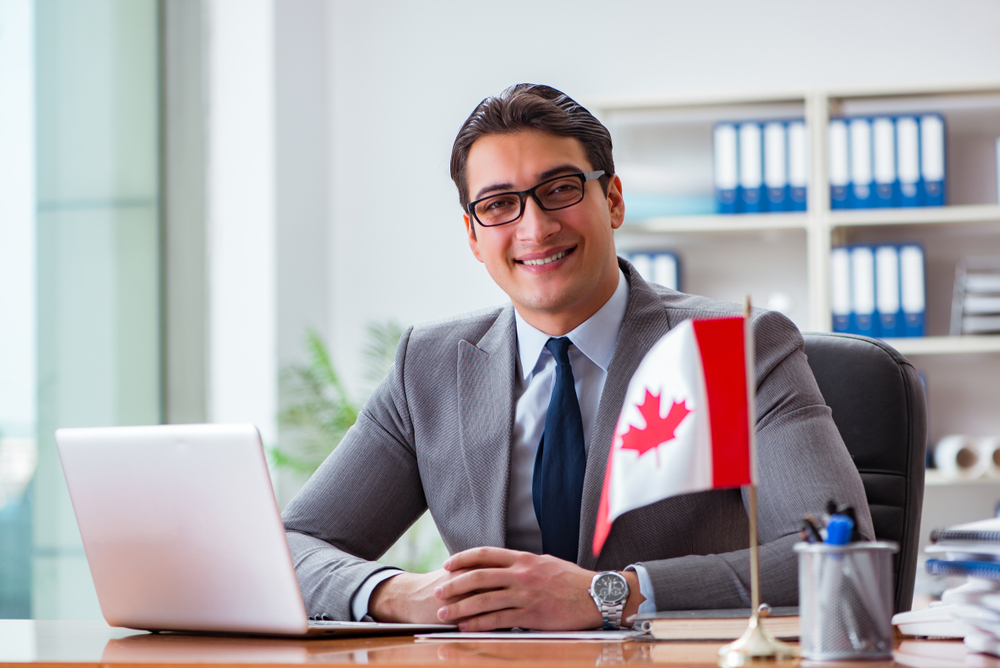 What Not to Do During a Canada Work Permit Interview: Businessman with Canadian flag in office