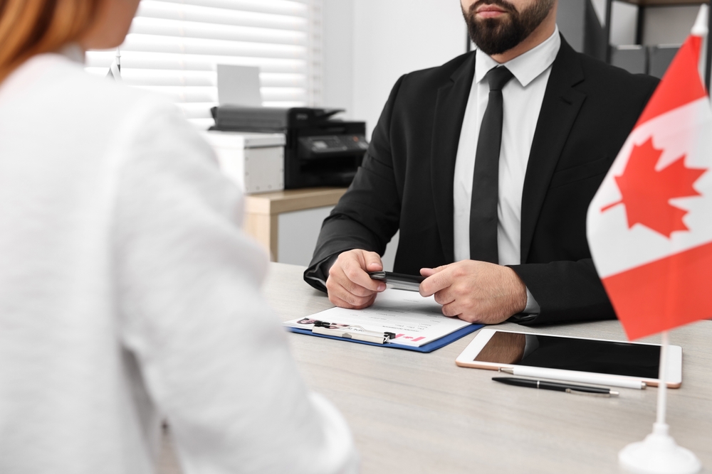 What Not to Say During a Canada Work Permit Interview: Photo of a woman having interview with embassy worker in office