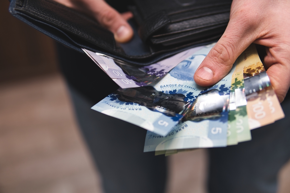 Minimum Wage in Canada: Canadian currency. Dollars. Money from Canada. Old retired person paying in cash.