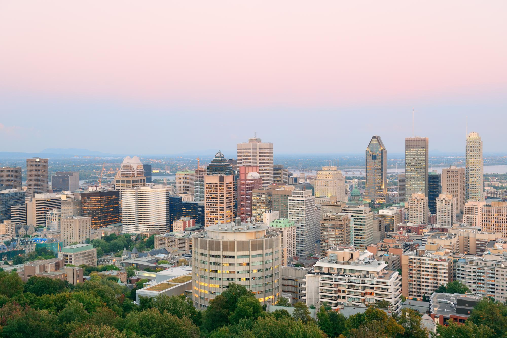 Montreal vs Calgary: Montreal city skyline at sunset viewed from Mont Royal with urban skyscrapers.